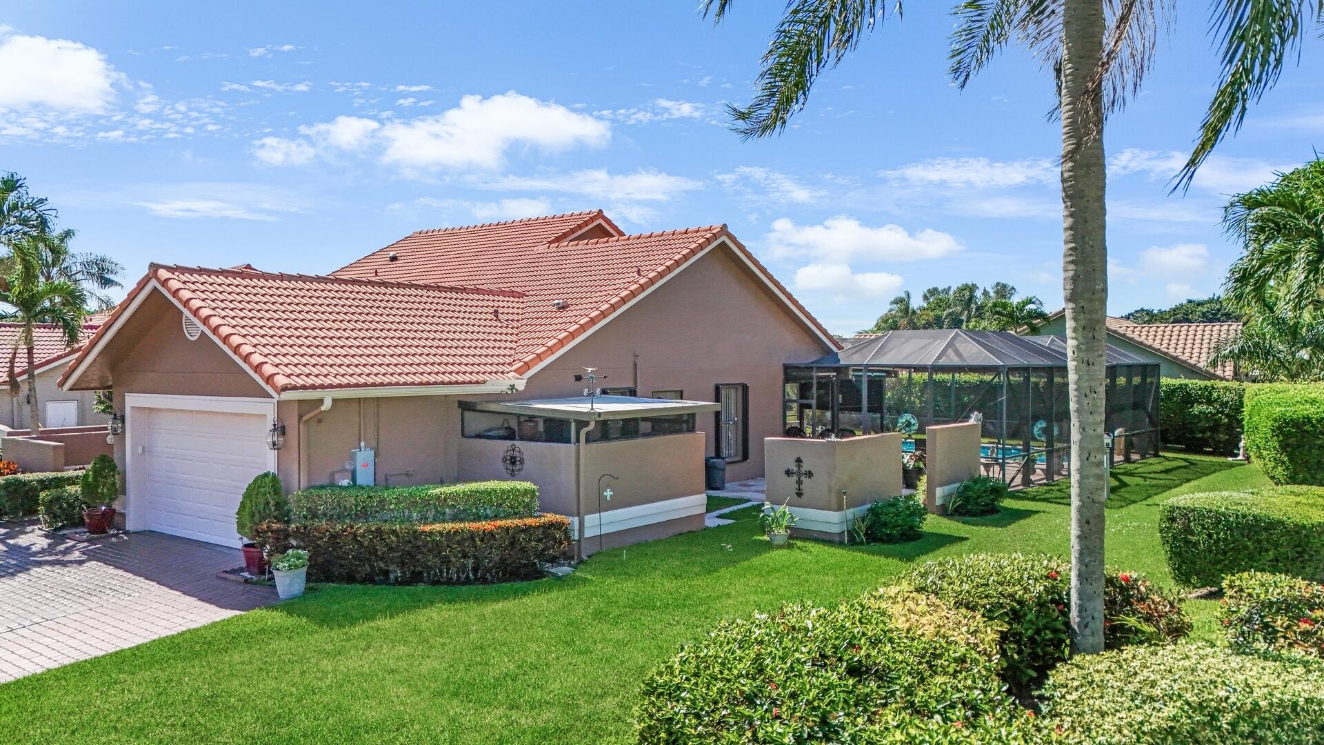 19261 Cherry Hills Terrace Boca Raton, FL 33498 - Photo 45 of 53 a front view of a house with a garden and plants