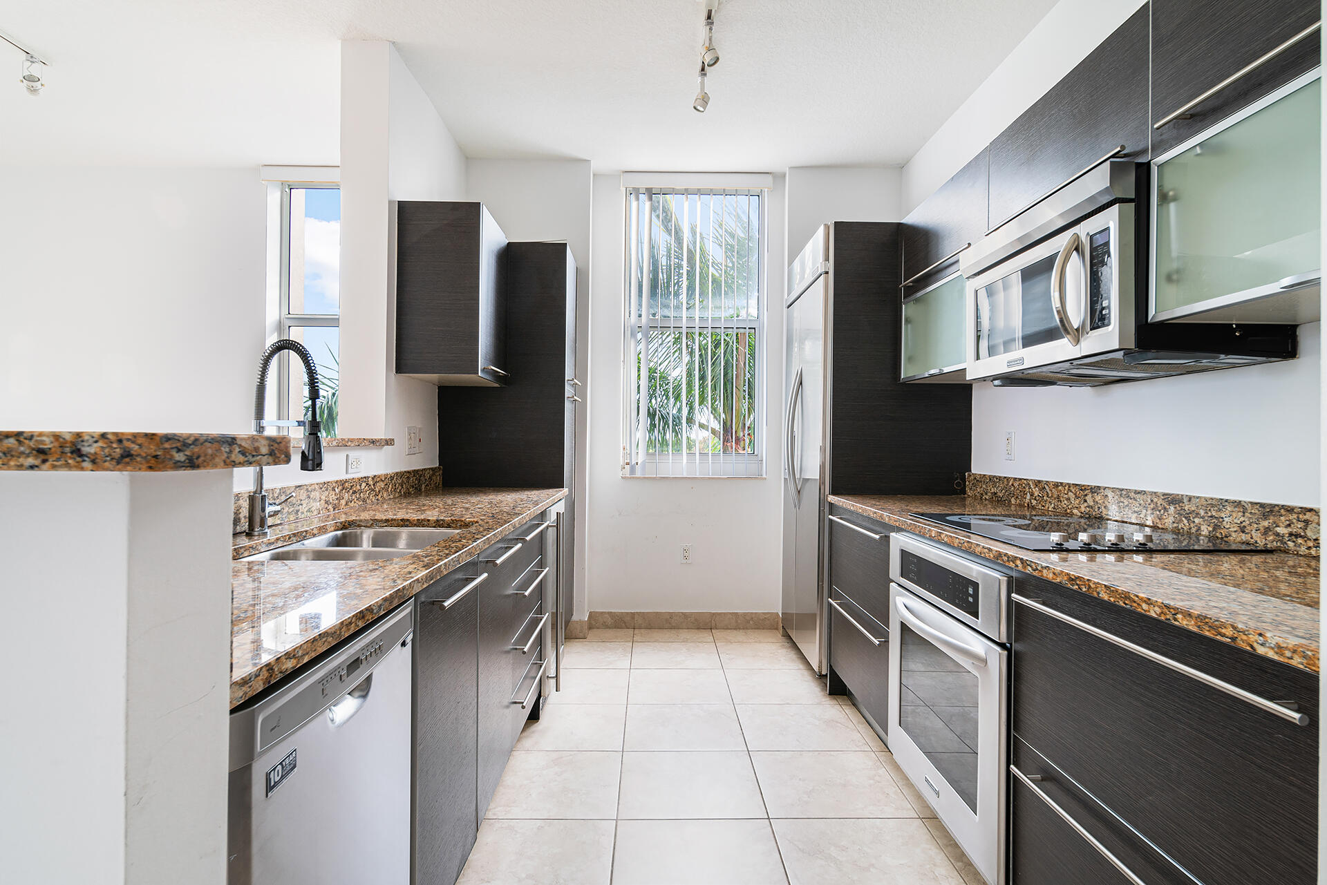 550 Okeechobee Boulevard, Unit 428 West Palm Beach, FL 33401 - Photo 5 of 29 a kitchen with stainless steel appliances granite countertop a sink stove and refrigerator
