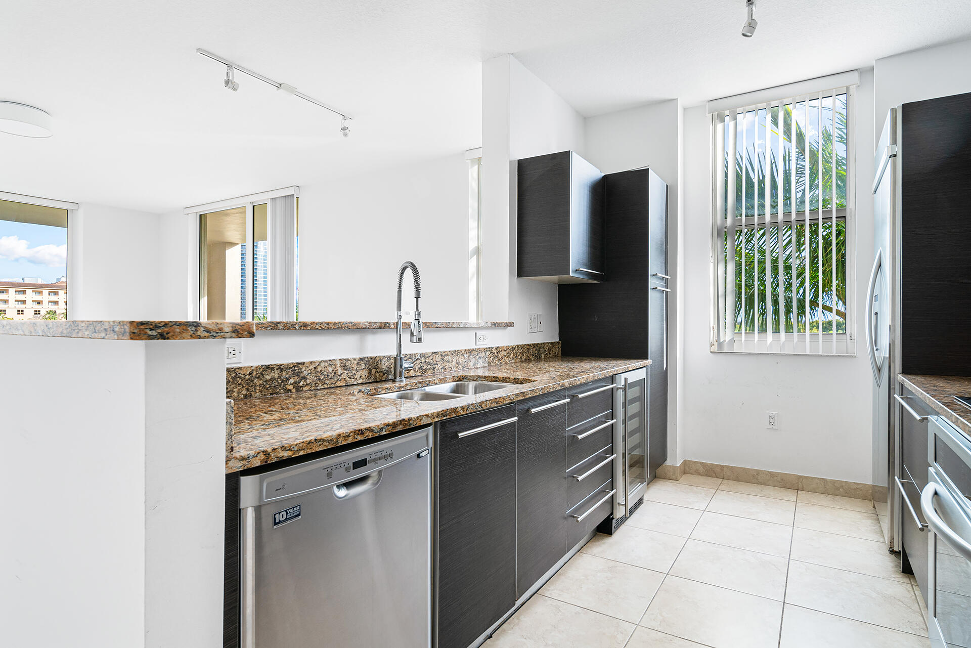 550 Okeechobee Boulevard, Unit 428 West Palm Beach, FL 33401 - Photo 7 of 29 a kitchen with stainless steel appliances granite countertop a sink and a refrigerator