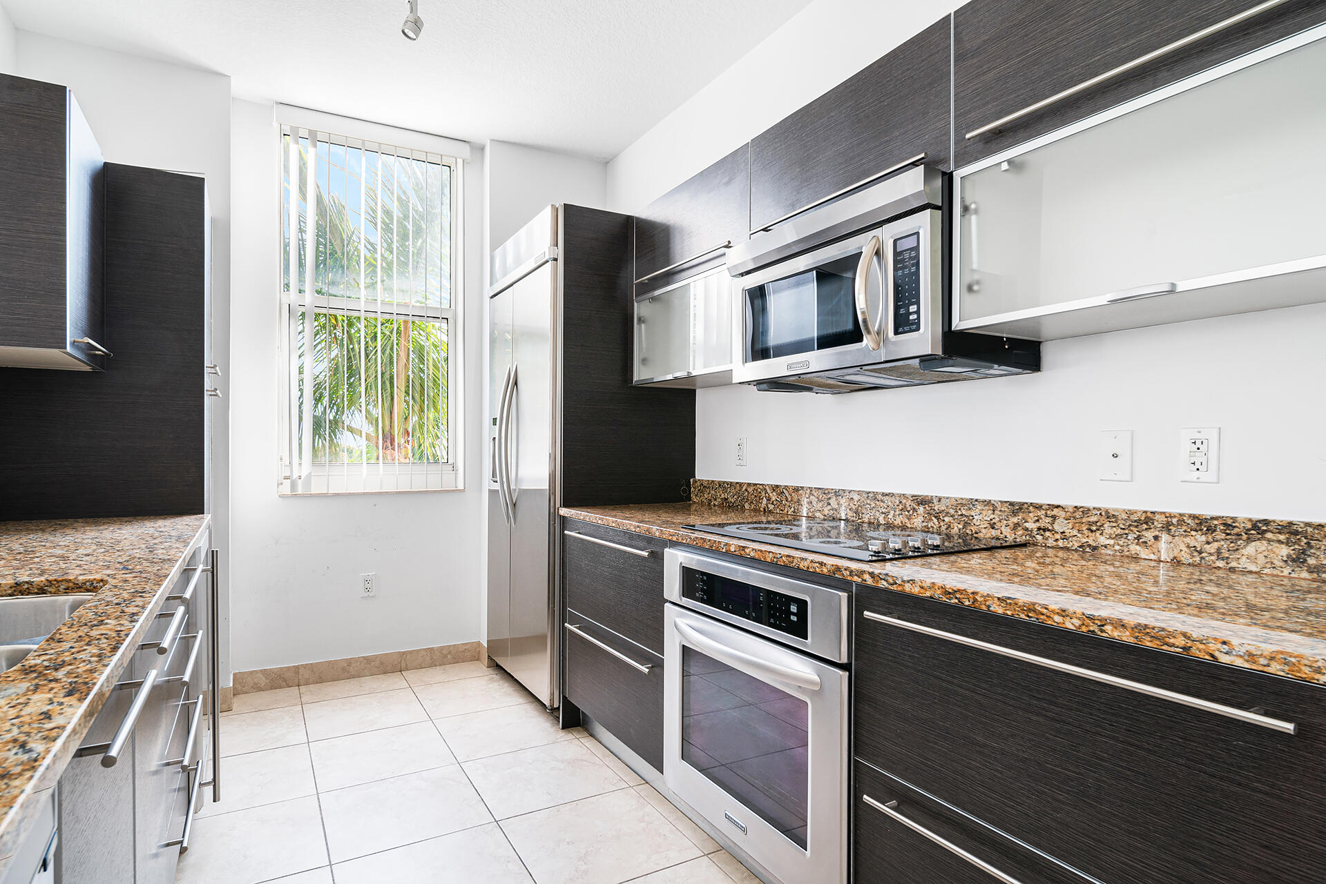 550 Okeechobee Boulevard, Unit 428 West Palm Beach, FL 33401 - Photo 8 of 29 a kitchen with granite countertop a refrigerator and a stove
