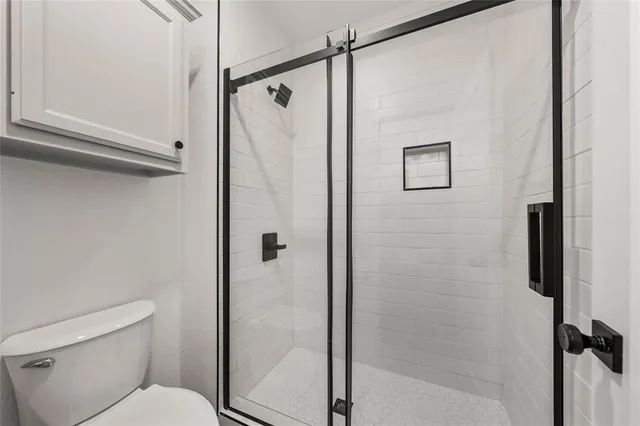 a bathroom with a shower a toilet and a shower