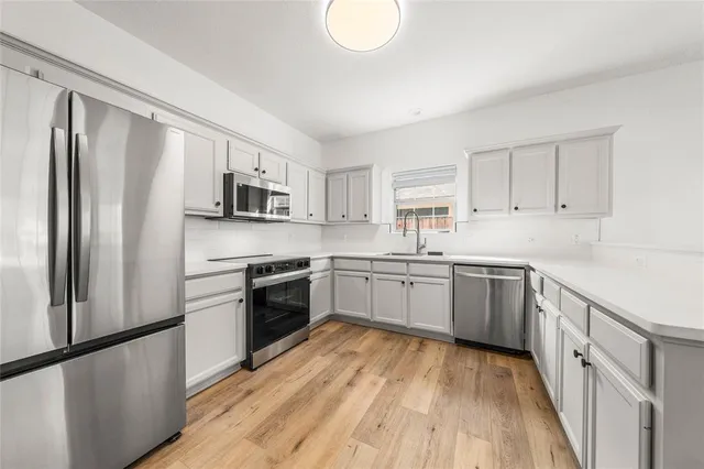 a kitchen with a refrigerator stove top oven and sink