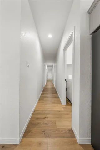 a view of a hallway with wooden floor and staircase