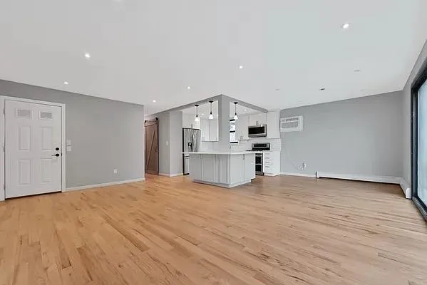 a view of empty room with cabinet and wooden floor