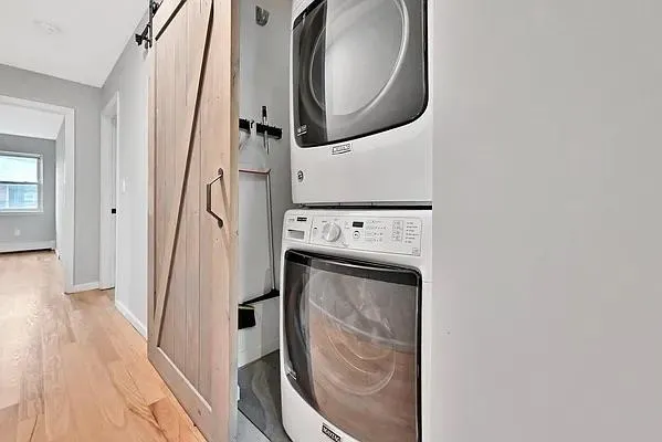 a utility room with wooden floor washer and dryer