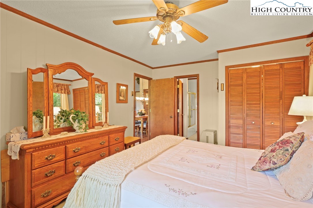 714 Pine Ridge Road Beech Mountain, NC 28604 - Photo 14 of 27 a bedroom with a large bed and a chandelier