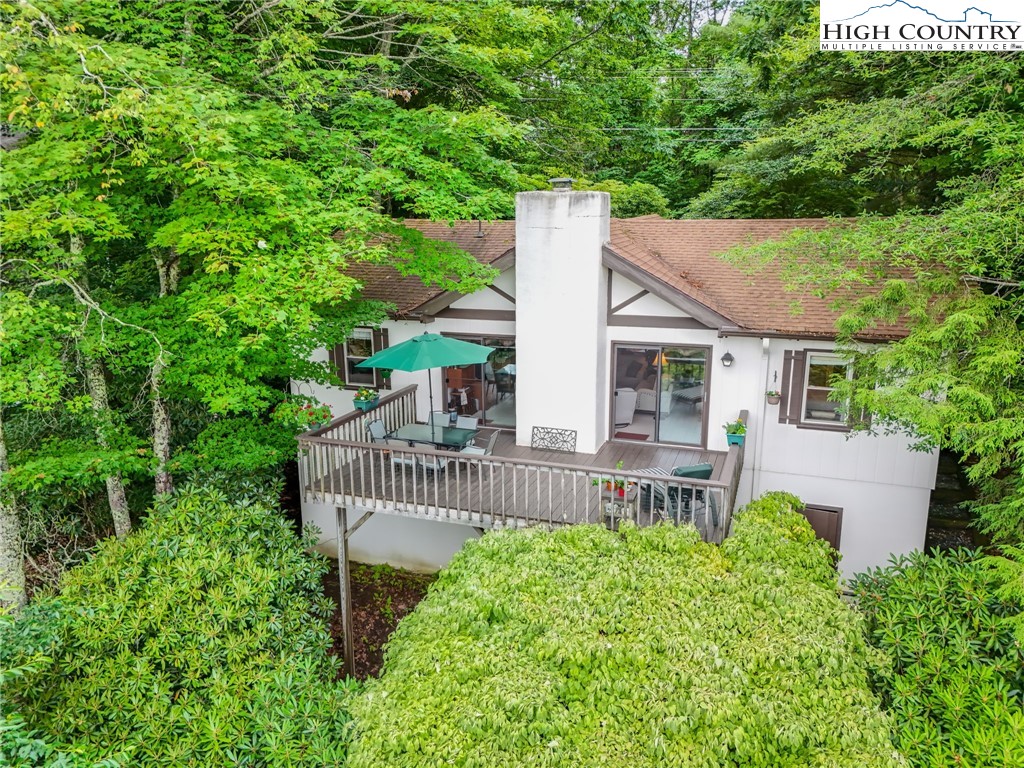 714 Pine Ridge Road Beech Mountain, NC 28604 - Photo 3 of 27 a view of a house with a small yard plants and large tree