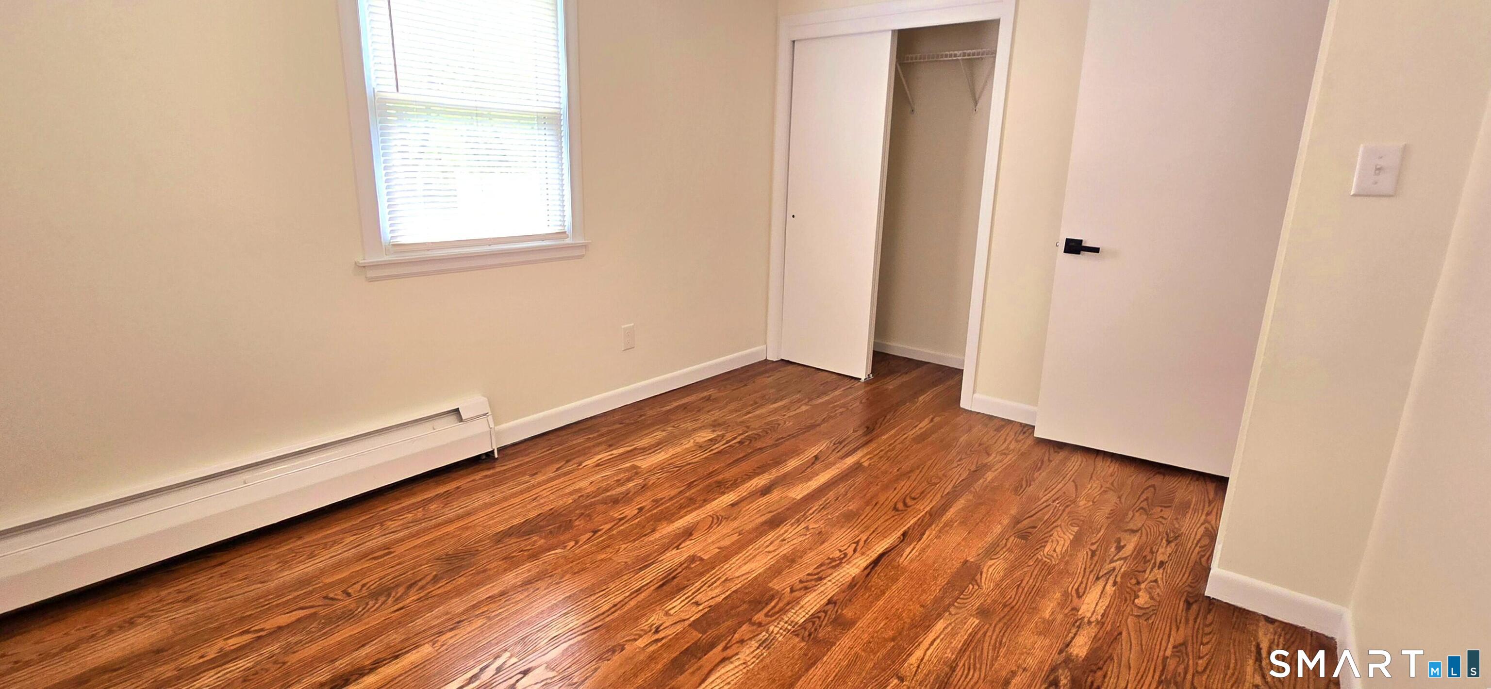 64 4th Street Bristol, CT 06010 - Photo 20 of 44 an empty room with wooden floor and windows