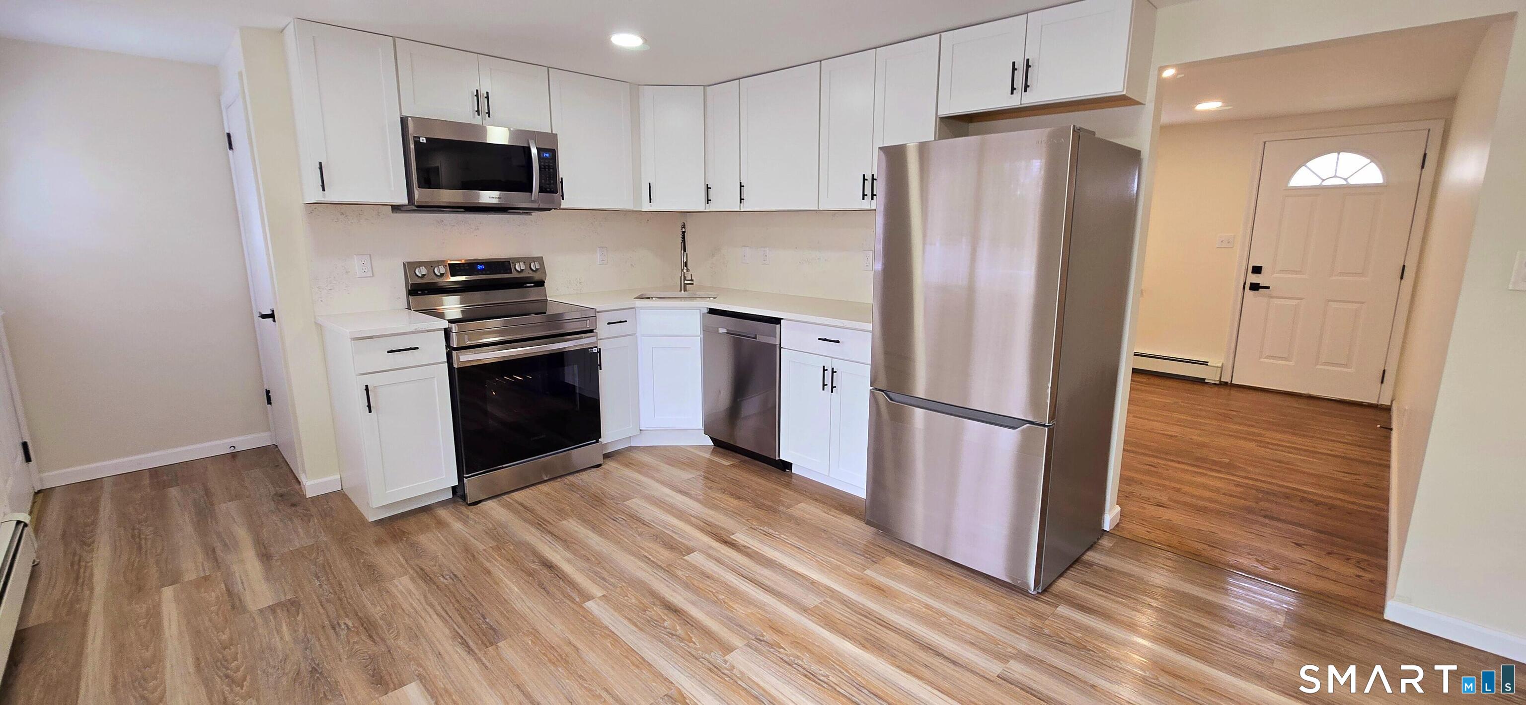 64 4th Street Bristol, CT 06010 - Photo 2 of 44 a kitchen with stainless steel appliances a refrigerator stove and wooden floor