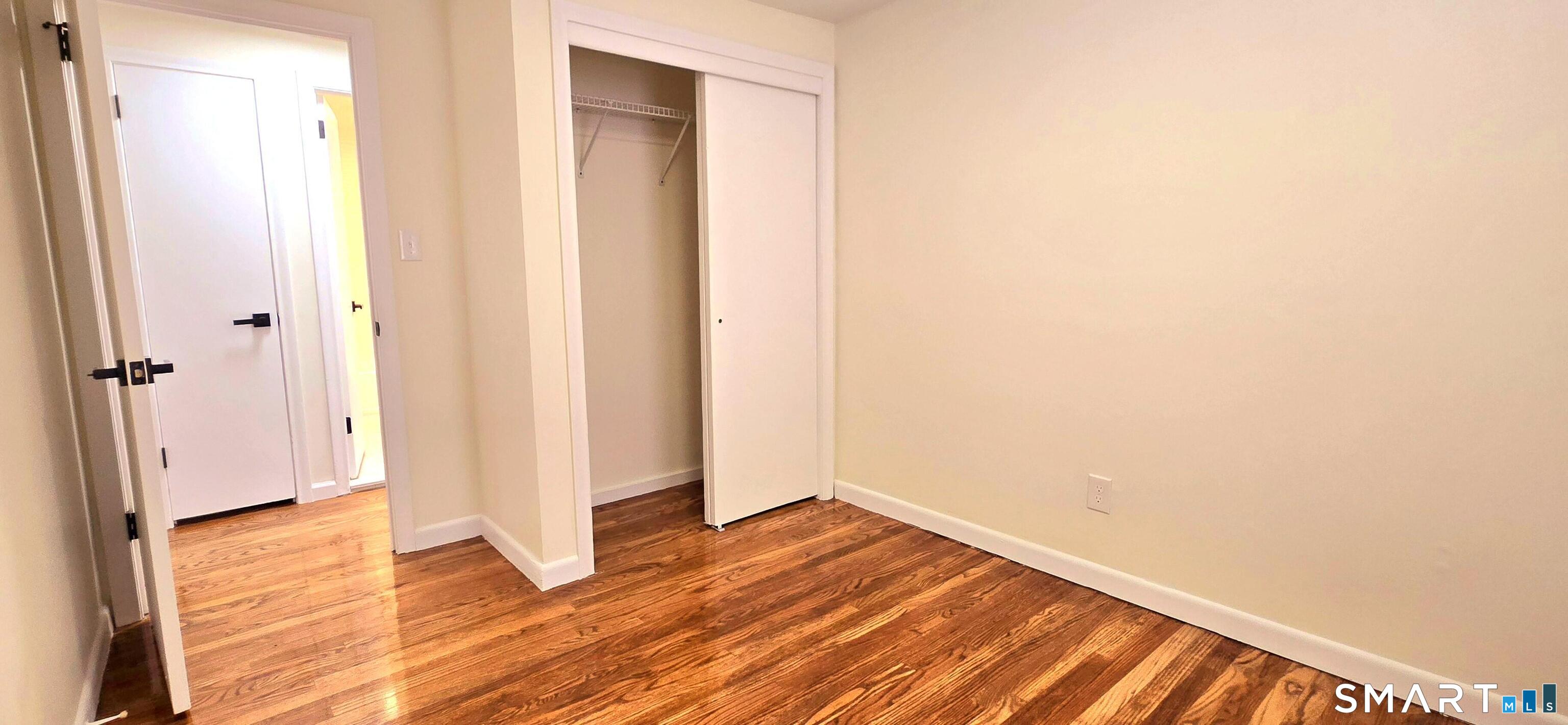 64 4th Street Bristol, CT 06010 - Photo 22 of 44 a view of an empty room with wooden floor and a bathroom