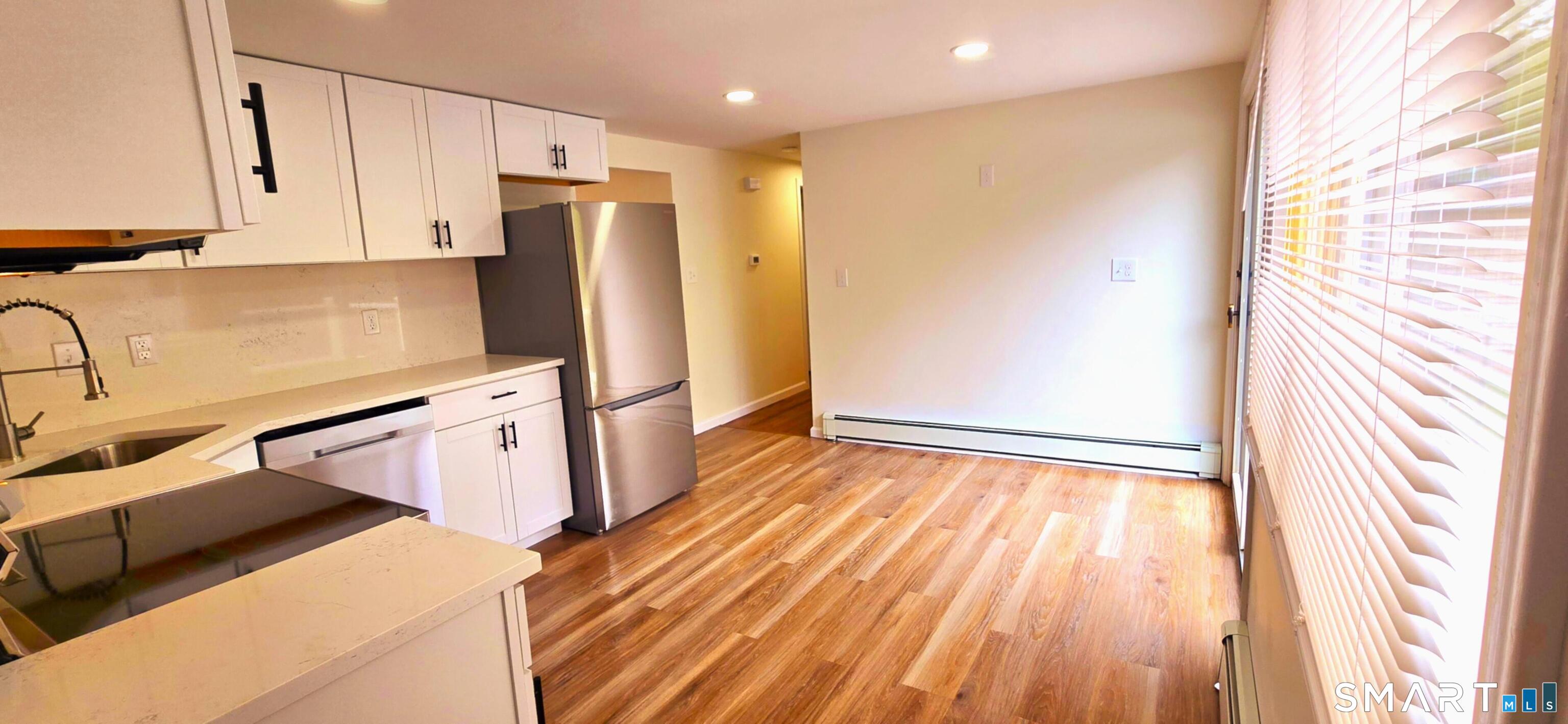 64 4th Street Bristol, CT 06010 - Photo 3 of 44 a kitchen with stainless steel appliances a refrigerator and a stove top oven