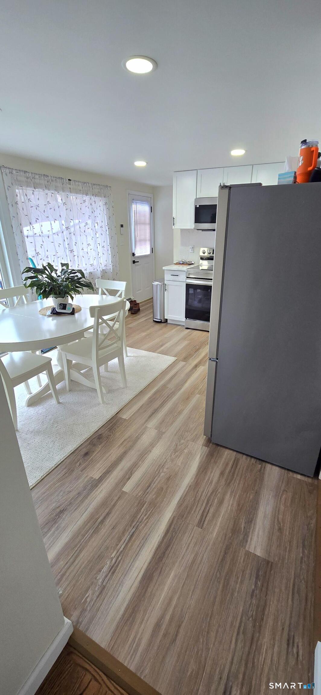 64 4th Street Bristol, CT 06010 - Photo 9 of 44 a living room with stainless steel appliances kitchen island granite countertop furniture and a fireplace