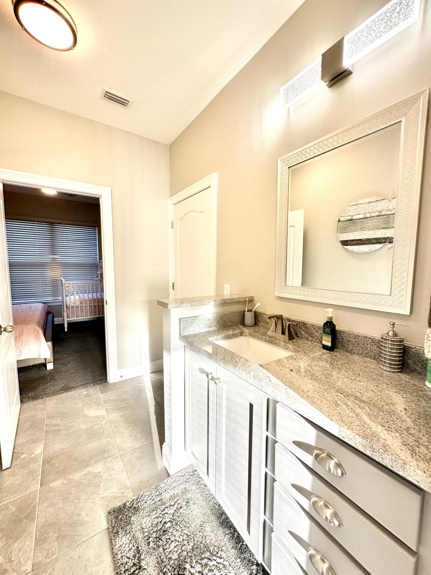1207 Tallokas Road Crestview, FL 32536 - Photo 39 of 58 a bathroom with a granite countertop sink and a mirror