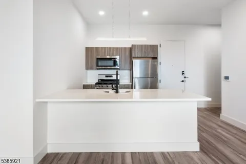 a kitchen with kitchen island a sink appliances and cabinets