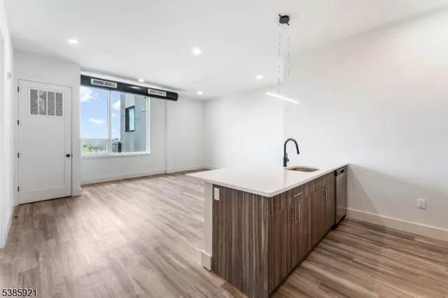 a view of a kitchen with sink and wooden floor