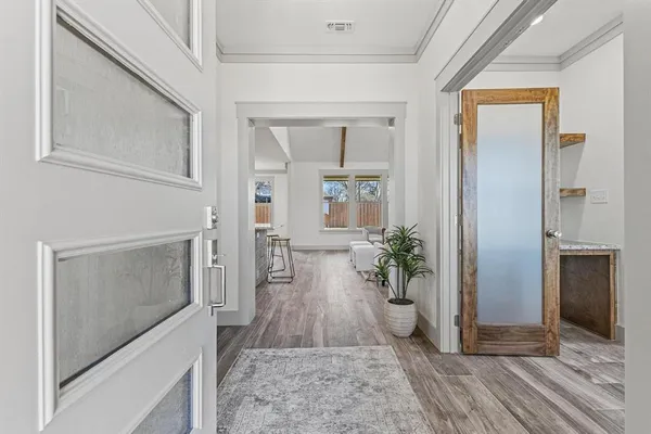 a view of a hallway with wooden floor and a living room
