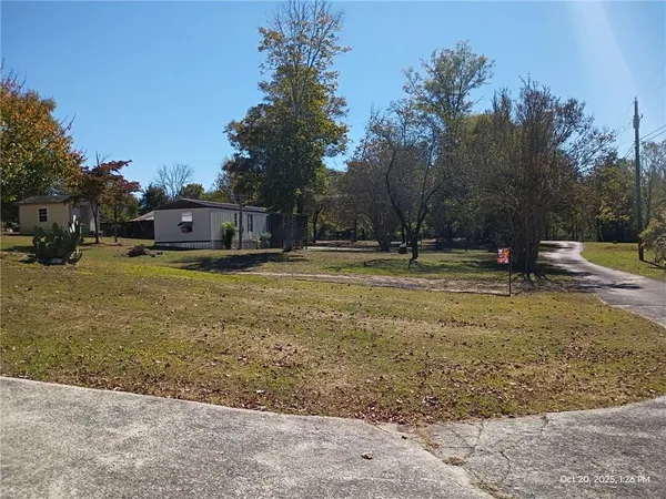 a front view of a house with a yard and trees