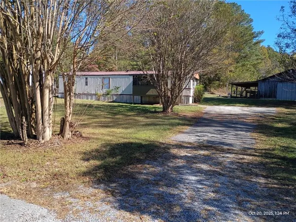 a front view of a house with a yard and trees