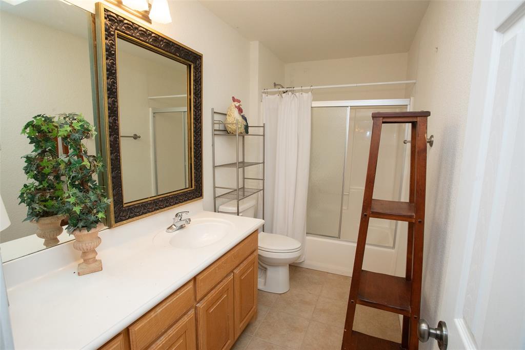 1204 Eagle Point Road Graford, TX 76449 - Photo 18 of 30 a bathroom with a sink a toilet and a mirror