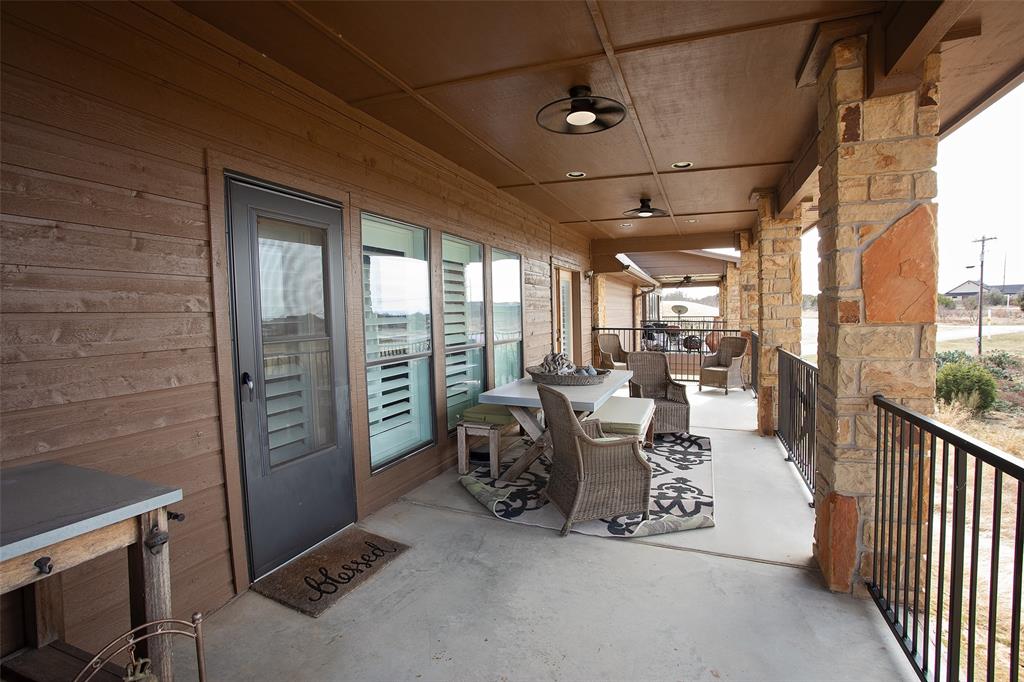 1204 Eagle Point Road Graford, TX 76449 - Photo 19 of 30 a living room with furniture a flat screen tv and a floor to ceiling window