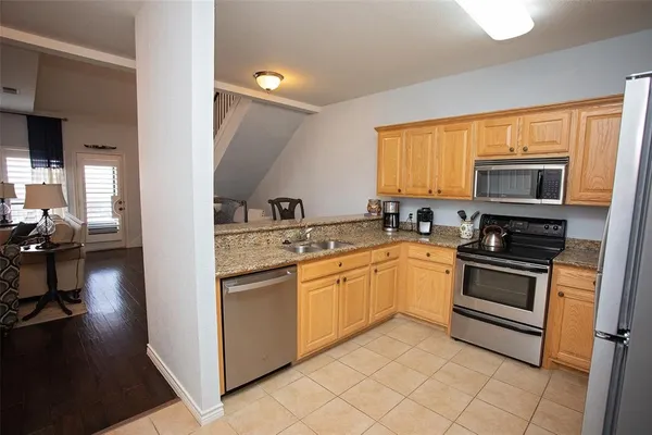 a kitchen with stainless steel appliances granite countertop a stove a sink and a microwave