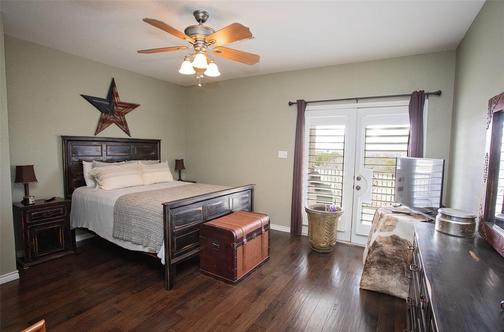 1204 Eagle Point Road Graford, TX 76449 - Photo 10 of 30 a bedroom with a bed a chandelier and a large window