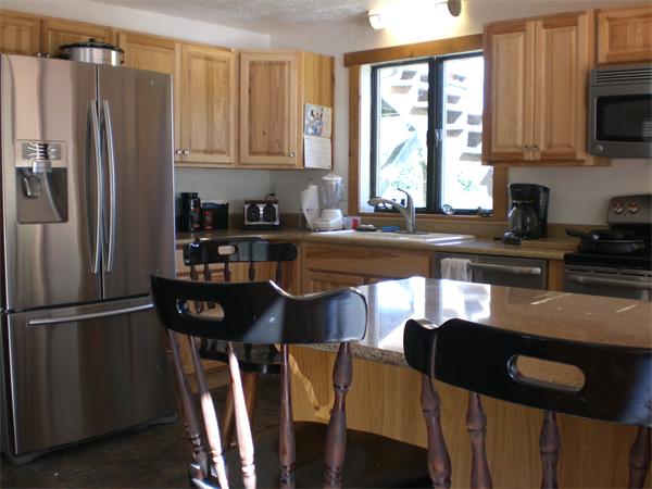 698 Town Farm Road Warren, MA 01083 - Photo 14 of 19 a kitchen with stainless steel appliances granite countertop a refrigerator a stove a sink dishwasher with a dining table and chair with wooden floor
