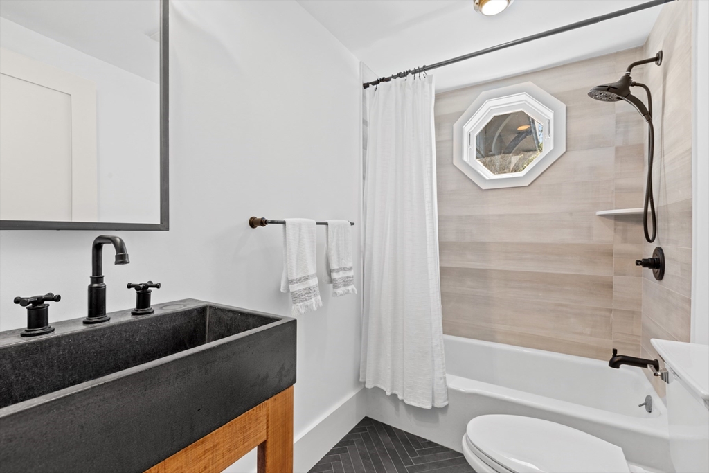 56 Hill Top Road Gloucester, MA 01930 - Photo 28 of 35 a bathroom with a sink a mirror a bathtub and shower