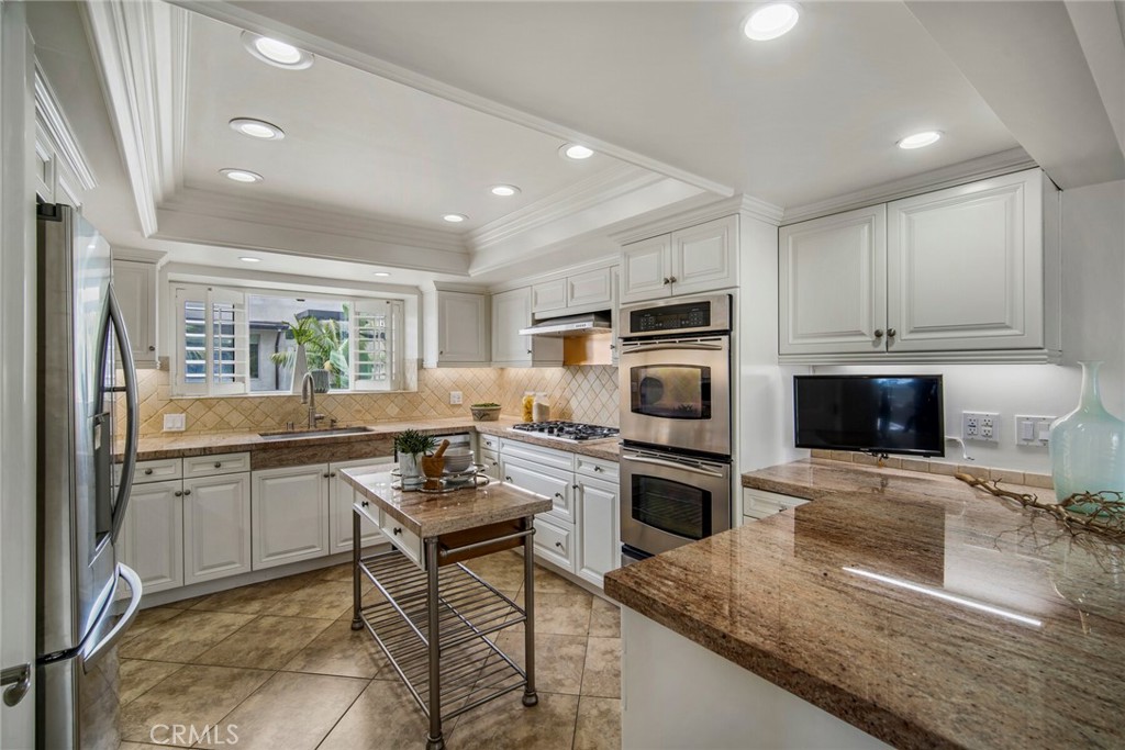 32041 Point Place Laguna Beach, CA 92651 - Photo 13 of 59 a kitchen with stainless steel appliances granite countertop a stove top oven a sink dishwasher a dining table and chairs with wooden floor