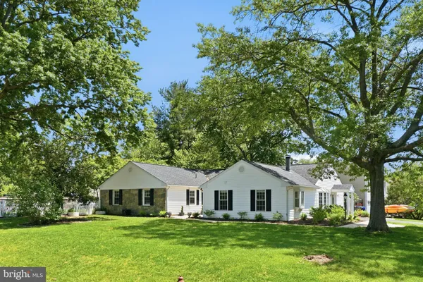 a front view of a house with a garden and trees