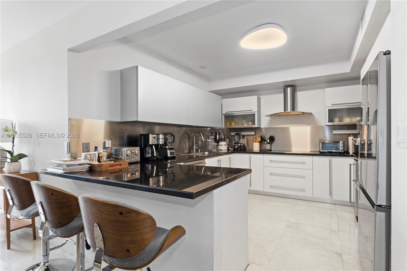 765 Crandon Boulevard, Unit 506 Key Biscayne, FL 33149 - Photo 11 of 19 a kitchen with stainless steel appliances granite countertop a sink a stove and a refrigerator