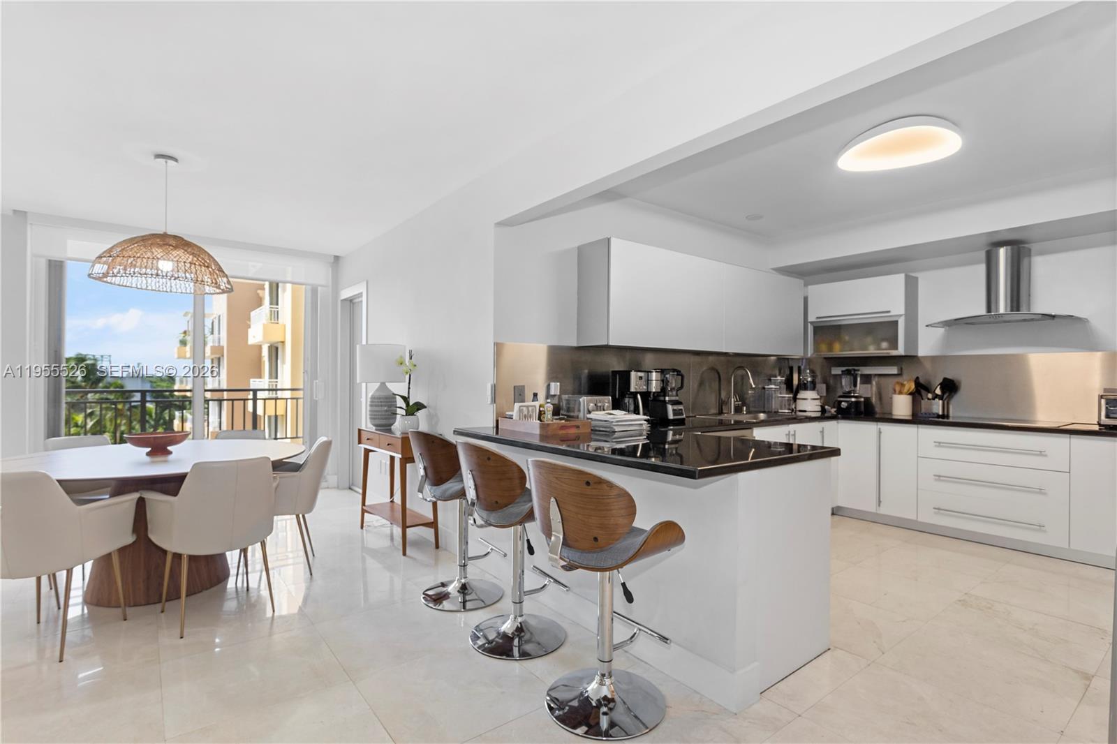 765 Crandon Boulevard, Unit 506 Key Biscayne, FL 33149 - Photo 14 of 19 a kitchen with sink a table and chairs in it