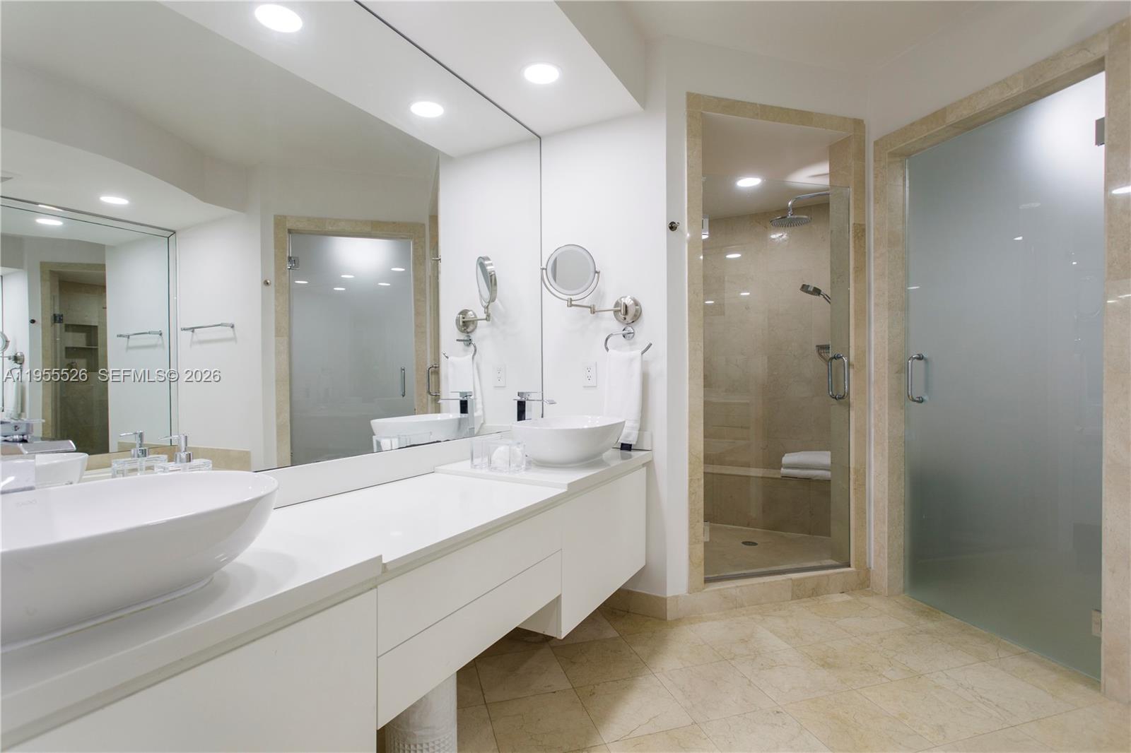 765 Crandon Boulevard, Unit 506 Key Biscayne, FL 33149 - Photo 4 of 19 a bathroom with a sink a shower and a mirror