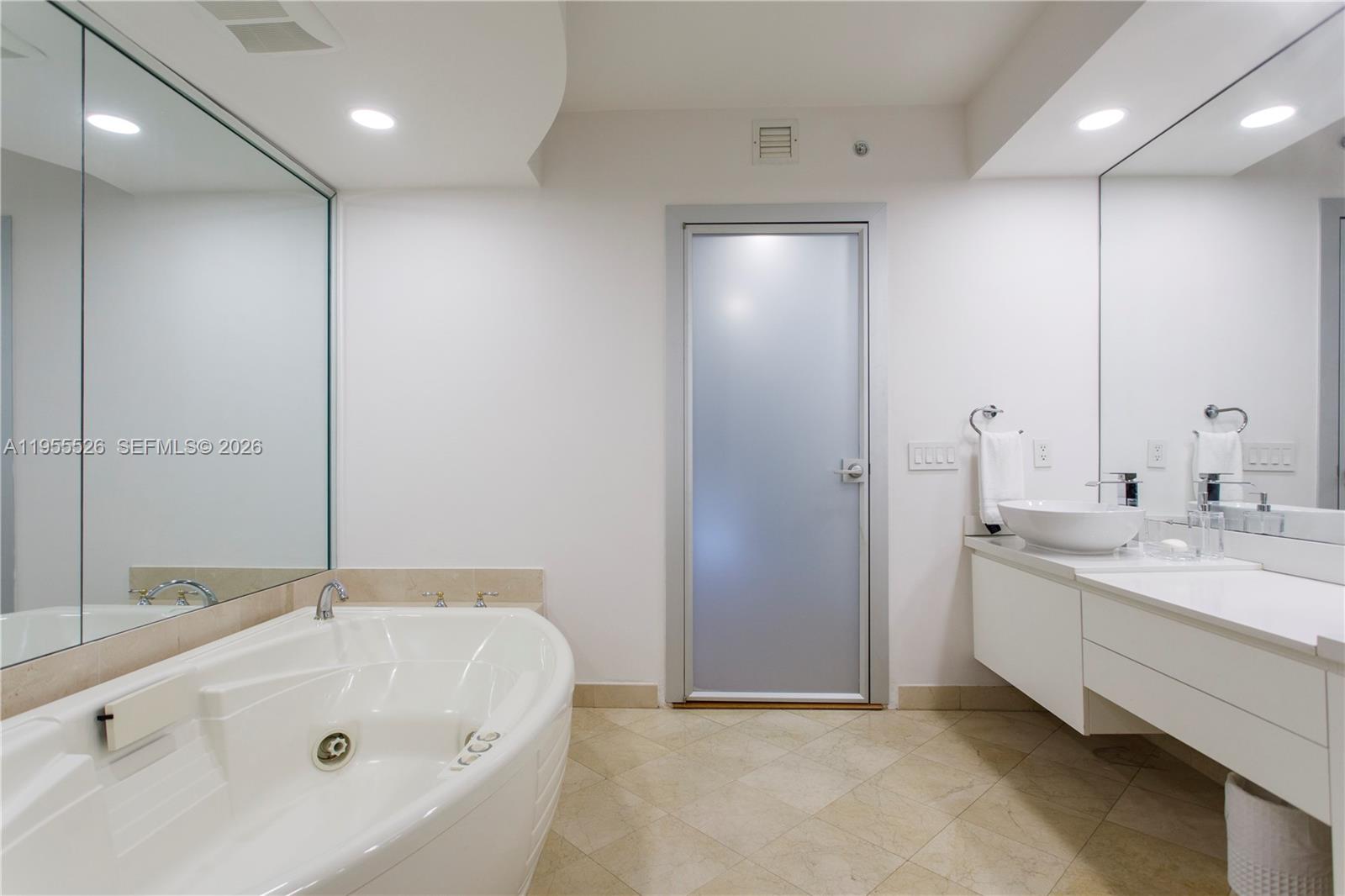 765 Crandon Boulevard, Unit 506 Key Biscayne, FL 33149 - Photo 5 of 19 a bathroom with a tub sink and mirror