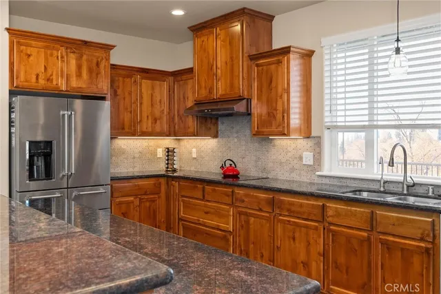 a kitchen with stainless steel appliances granite countertop a sink a stove and a center island