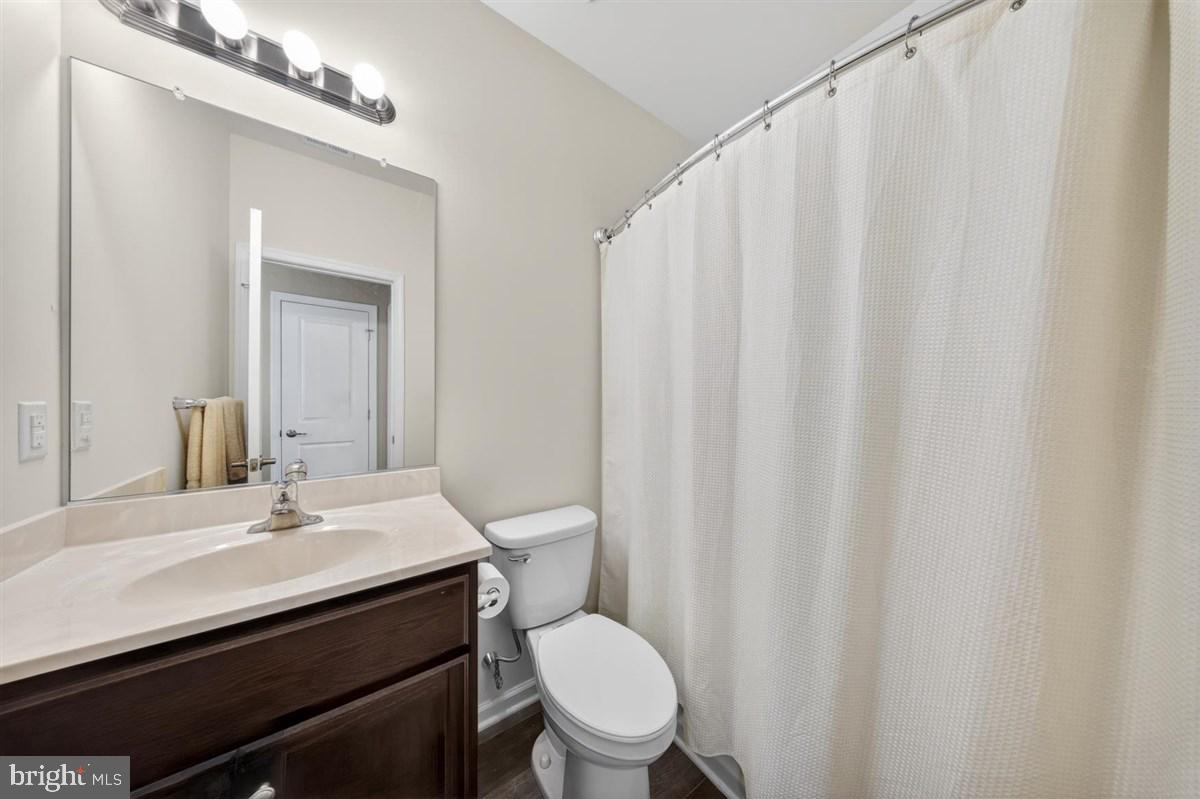 1426 Whispering Woods Road Middletown, DE 19709 - Photo 26 of 37 a bathroom with a sink a toilet a mirror and shower curtain