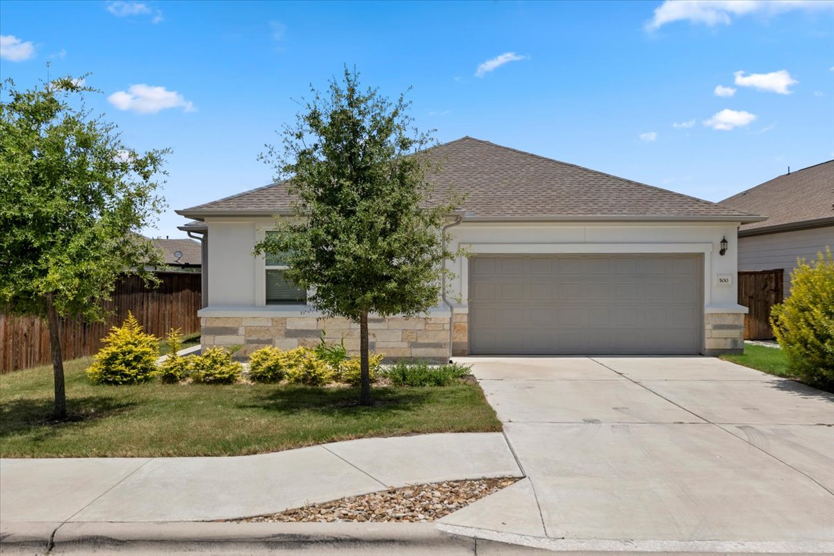 500 Stinchcomb Road Hutto, TX 78634 - Photo 1 of 37 A neatly maintained lawn and mature trees frame this inviting front elevation with a two-car garage.