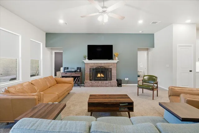a living room with furniture a flat screen tv and a fireplace