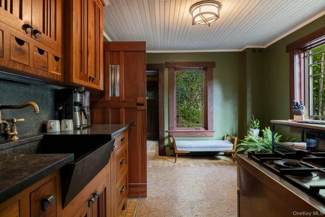 a kitchen with granite countertop a stove a sink and dishwasher wooden cabinets with granite countertops