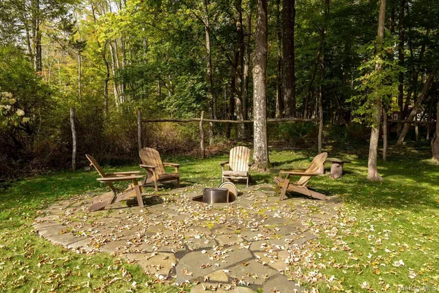 a view of a lake with chairs and table in the patio