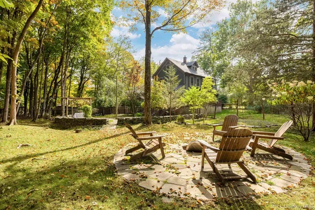 a view of backyard of house with outdoor seating and trees
