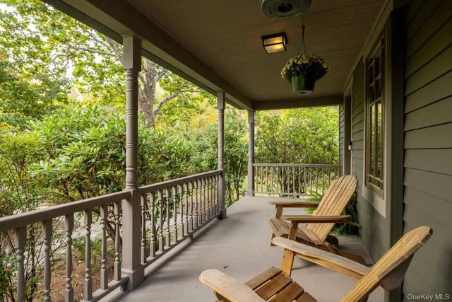 a view of a balcony with chairs and floor to ceiling window