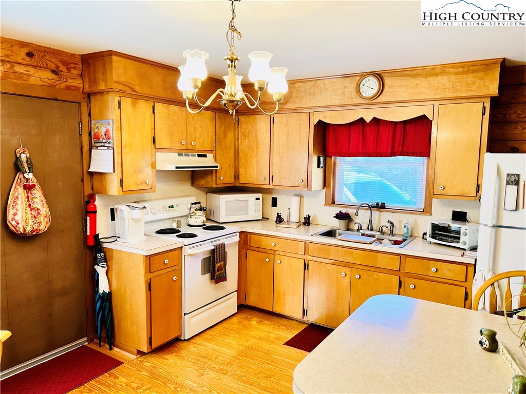 840 Golf Course Road Sparta, NC 28675 - Photo 8 of 35 a kitchen with a sink a stove and a chandelier