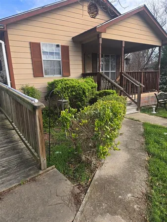 a view of a house with a small yard and flower plants