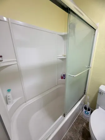 a bathroom with a toilet and a shower