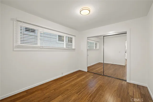 a view of a room with wooden floor and a window