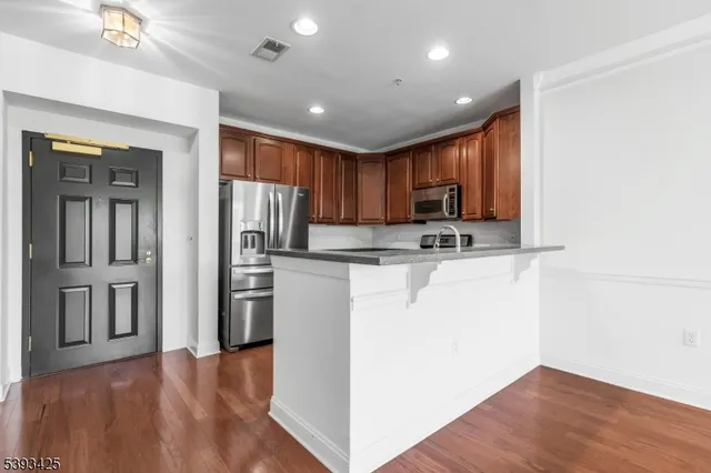 a kitchen with stainless steel appliances granite countertop a refrigerator microwave and sink