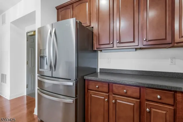 a close view of a refrigerator in kitchen and stainless steel appliances wooden floor