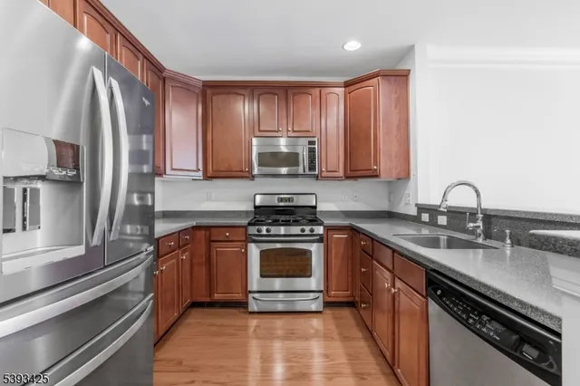 a kitchen with stainless steel appliances granite countertop a stove a sink and a refrigerator