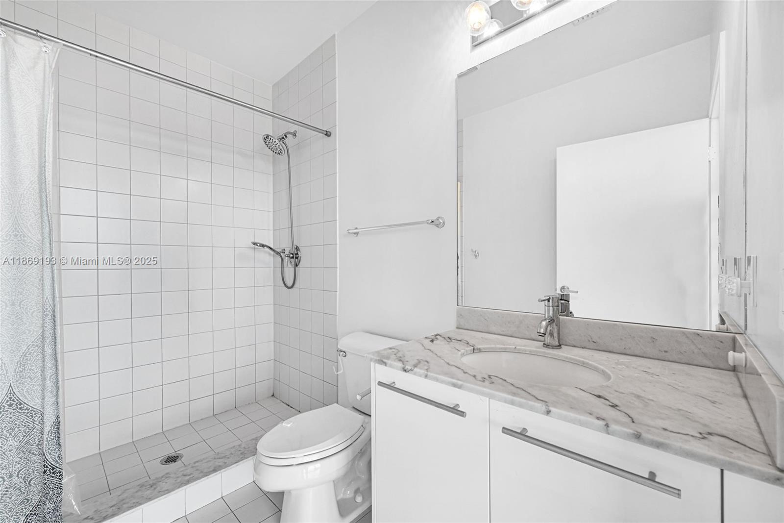 888 Biscayne Boulevard, Unit 5010 Miami, FL 33132 - Photo 12 of 18 a bathroom with a granite countertop sink a toilet and shower